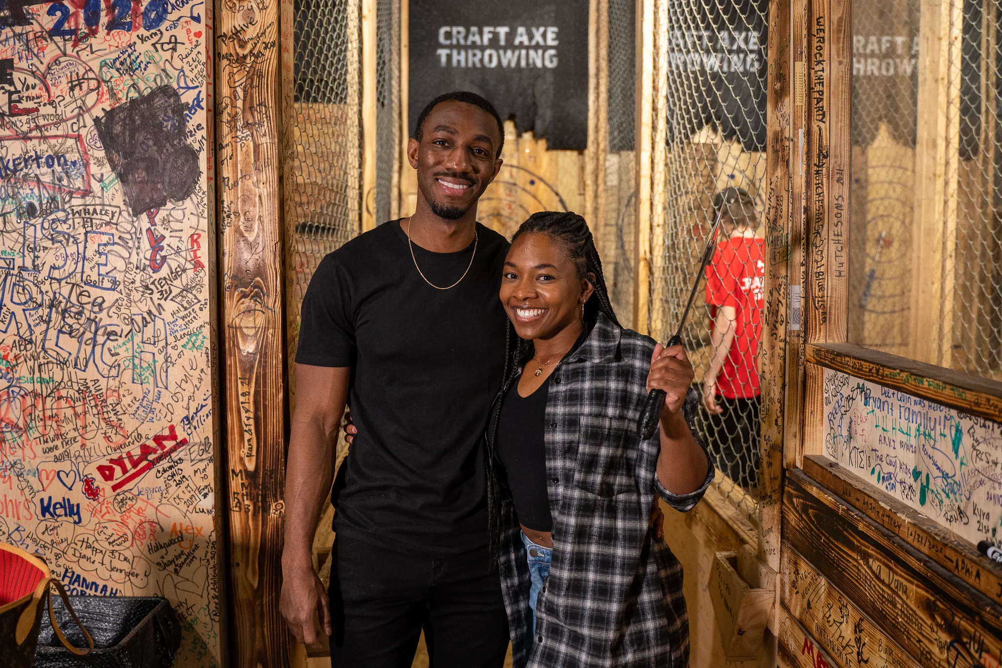 Couple throwing axes at a walk-in open throwing session